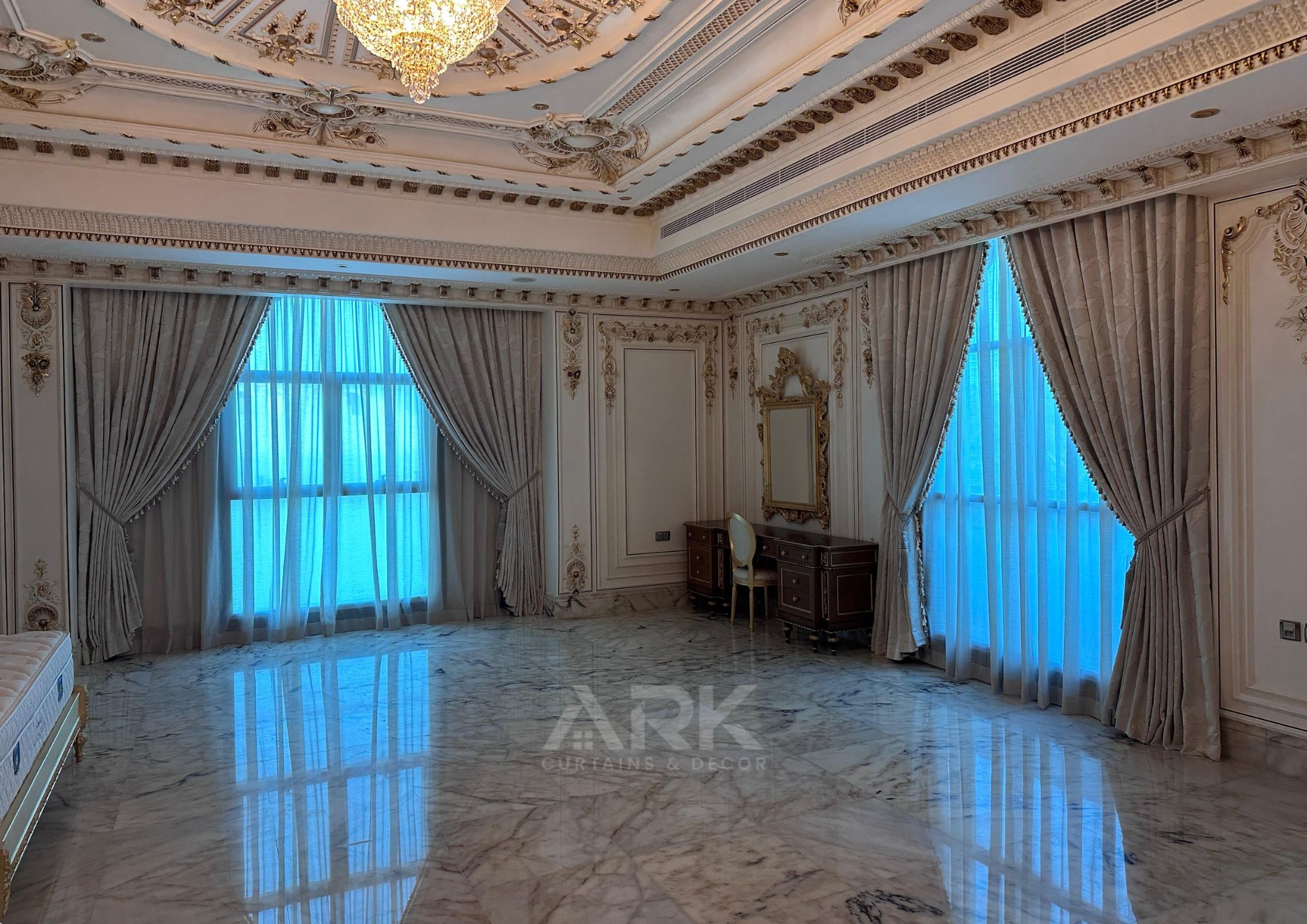 Luxury bedroom with layered sheer and blackout curtains and marble flooring