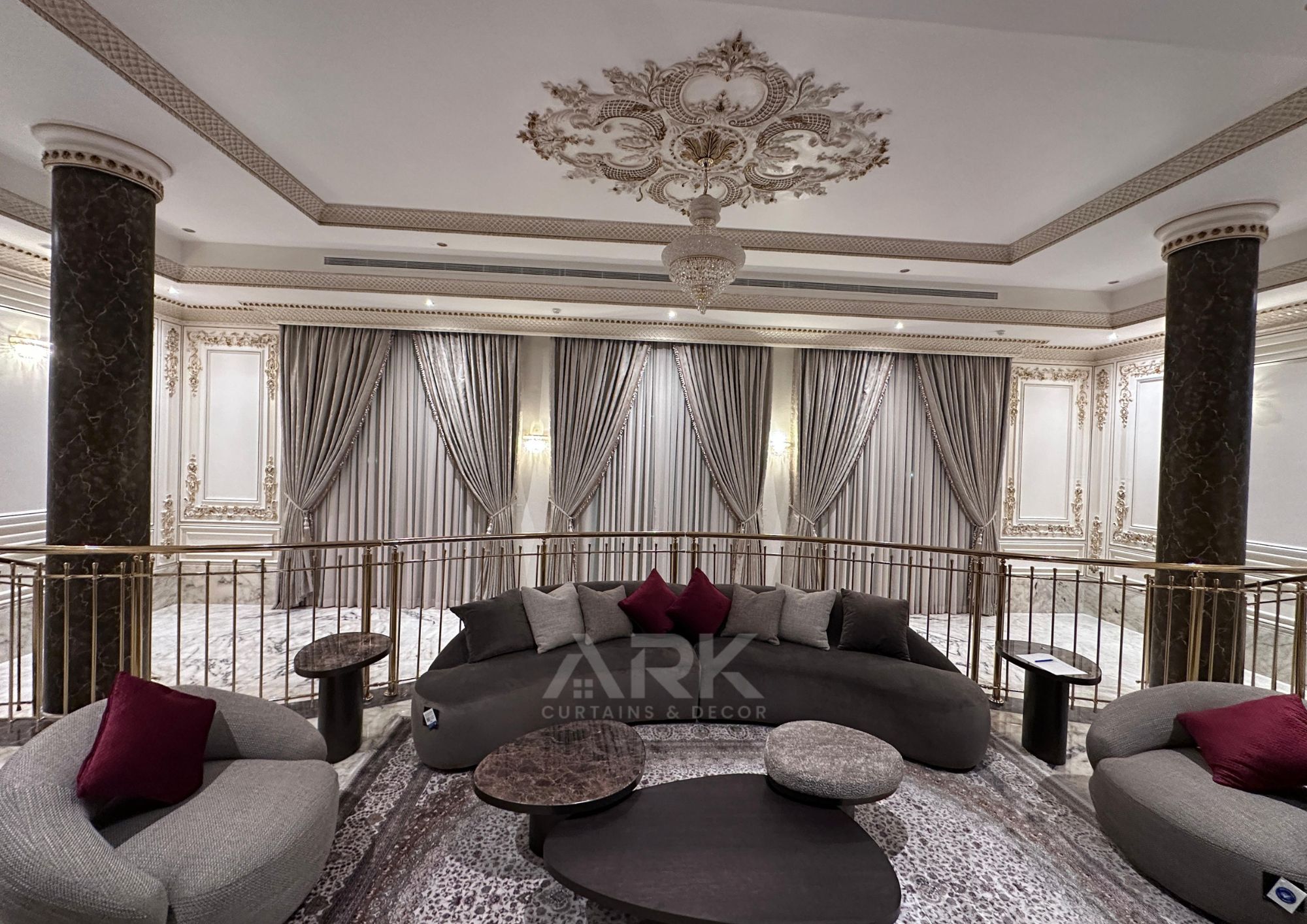 Grand majlis with floor-to-ceiling curtains, ornate ceiling and plush seating